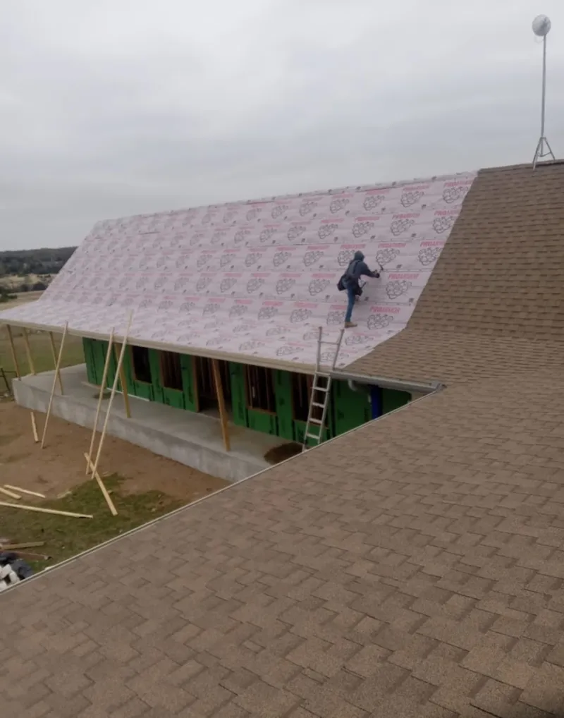 Worker preparing underlayment for a metal roof installation in Ottawa